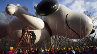 Workers prepare the giant Snoopy balloon before the 87th Annual Macy's Thanksgiving Day Parade on Thursday in New York. John Minchillo/AP