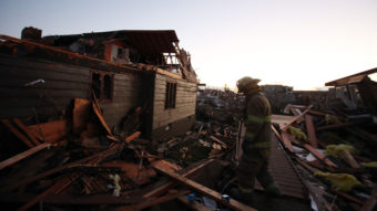 A firefighter searches through debris in Washington, Ill., on Sunday. Tornadoes and severe weather roared through the area earlier in the day. Tasos Katopodis/Getty Images