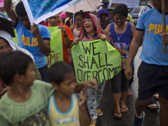 Some people marched in the rain Tuesday in the Philippine city of Tacloban, which was crushed by Typhoon Haiyan. David Guttenfelder/AP