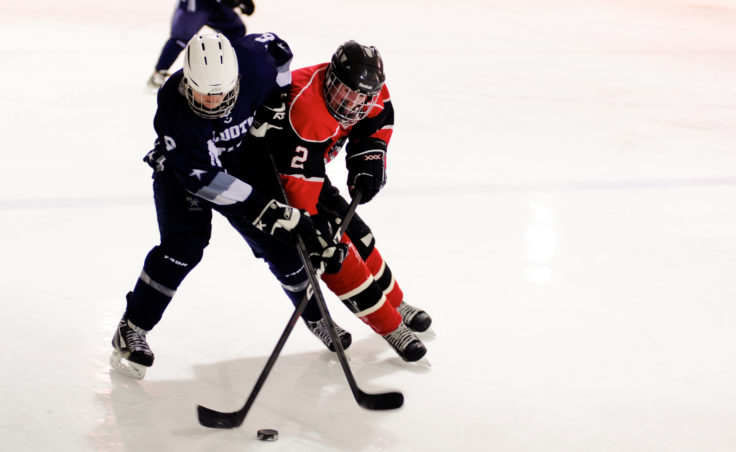 Juneau captain Grant Ainsworth battles Stephen Endsley for the puck in the team’s season opener at Treadwell Ice Arena.