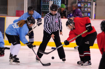 Referee Rich Morris drops the puck for Kim Milton (blue) and Mindy Shaw to battle for during the 10th Annual Jamboree women’s hockey tournament at Treadwell Ice Arena.