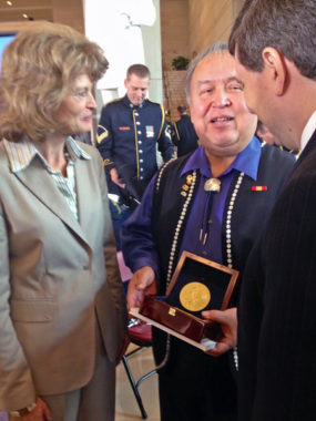 Ozzie Sheakley hold the Congressional Gold Medal awarded to the Tlingit Tribe for code talking service during World War II. He speaks to Sens. Lisa Murkowski and Mark Begich after the ceremony. (Photo by Liz Ruskin, APRN – Washington DC.)