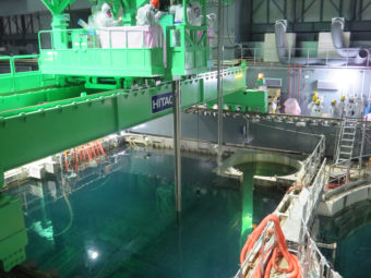 Workers remove nuclear fuel rods from a pool at the Unit 4 reactor of the Fukushima Daii-chi nuclear power plant on Monday. Handout/TEPCO