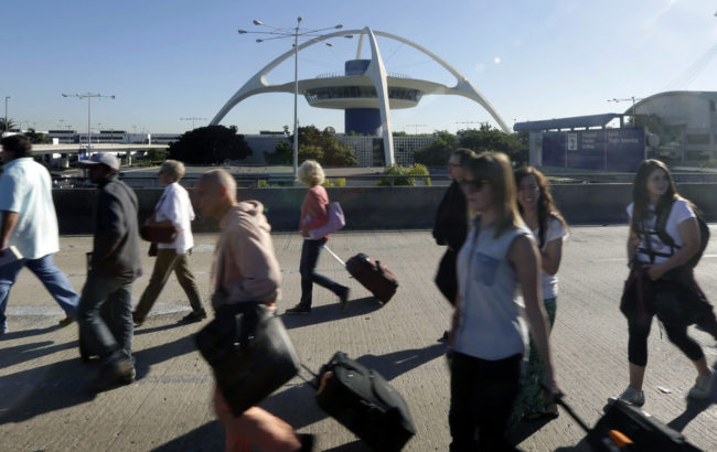 People exit Los Angeles International Airport in Los Angeles on Friday. Gregory Bull/AP