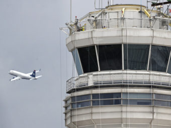 A passenger jet flies past the FAA control tower at Washington's Ronald Reagan National Airport. Cliff Owen/AP
