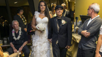 Saralyn Morales, center left, and Isajah Morales walk down the aisle at the Sheraton Waikiki in Honolulu Monday, shortly after Hawaii's new gay marriage law took effect. Marco Garcia/AP