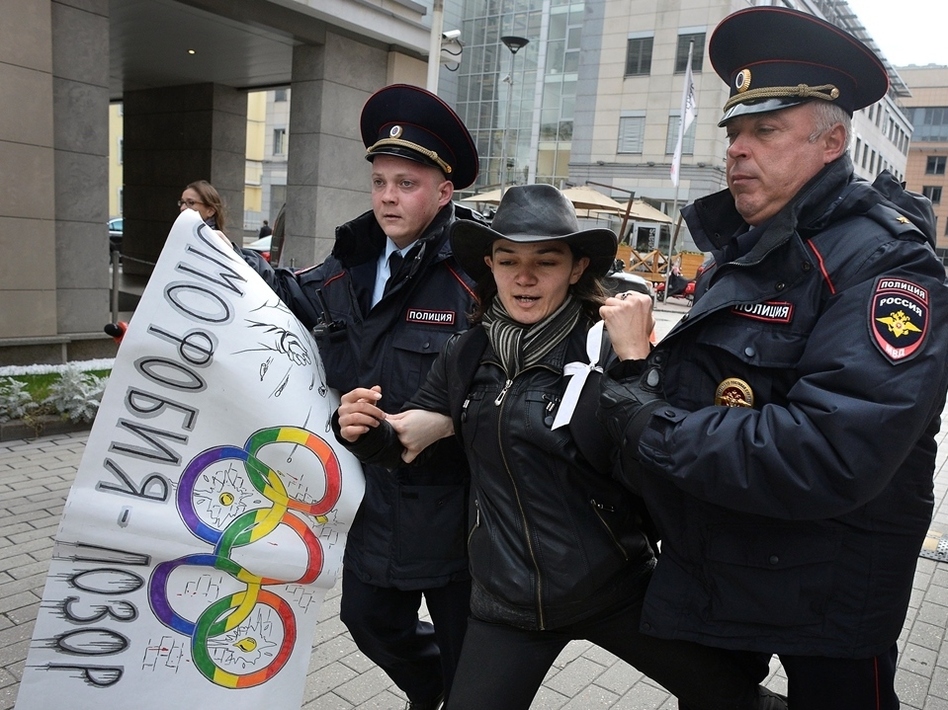 Sept. 25: Police detain a gay rights activist in Moscow. The poster, adorned with Olympic rings, reads "Homophobia is the shame of Russia!" Alexander Nemenov/AFP/Getty Images
