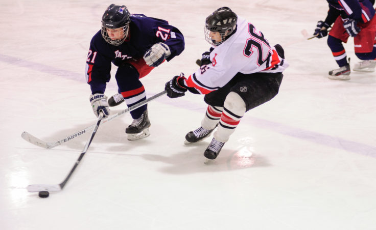 Juneau forward Josh Lahnum battles with North Pole’s James Laszoffy for the puck during the two-game series at Treadwell Ice Arena.