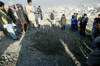 Afghans stand near a crater from an attack reportedly targeting the U.S. Embassy in Kabul on Wednesday. Ahmad Nazar/AP