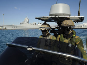 Norwegian marines patrol the waters around the Norwegian frigate HNOMS Helge Ingstad, which was docked in Cyprus over the weekend. The frigate, and the Danish warship HDMS Esbern Snare, will escort Danish and Norwegian cargo ships transporting Syria's most dangerous chemical weapons. Pavlos Vrionides/AP