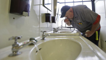 In West Virginia, a ban on water use has been lifted in at least three areas affected by a chemical spill. Here, Al Jones of the state's General Services department tests the water as he flushes a faucet and opens a restroom on the first floor of the Capitol in Charleston on Monday. Steve Helber/AP