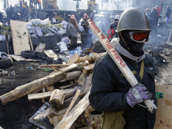 A protester guards a barricade in Kiev, Ukraine, on Monday. Darko Vojinovic/AP