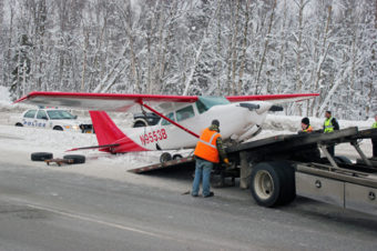 Crews load the Cessna 172 Cutlass onto a tow truck. (Photo by Josh Edge, APRN – Anchorage.)