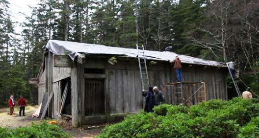The roof of Kasaan’s Chief Son-i-Hat House, also known as the Whale House, is covered by a tarp during repair work. (Organized Village of Kasaan.)