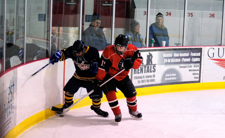 Juneau’s Zach Easton battles with Bartlett’s Raphael Turner during the weekend series at Treadwell Ice Arena.