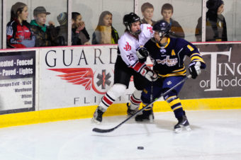 Ryan Liebelt fends off a checking attempt by Bartlett’s Kyle Sun during the weekend series at Treadwell Ice Arena.