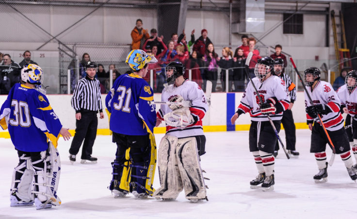 Juneau goalie Neal Chapman leads the traditional postgame handshake greeting counterpart Monroe Catholic’s Nathaniel Brose, who turned back 65 shots in two games against Juneau.