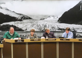 Noting the photo behind Assembly members, North Douglas resident Gene Randall compared a cellphone tower on Spuhn Island to a fictitious one at the Mendenhall Glacier. (Photo by Rosemarie Alexander/KTOO)