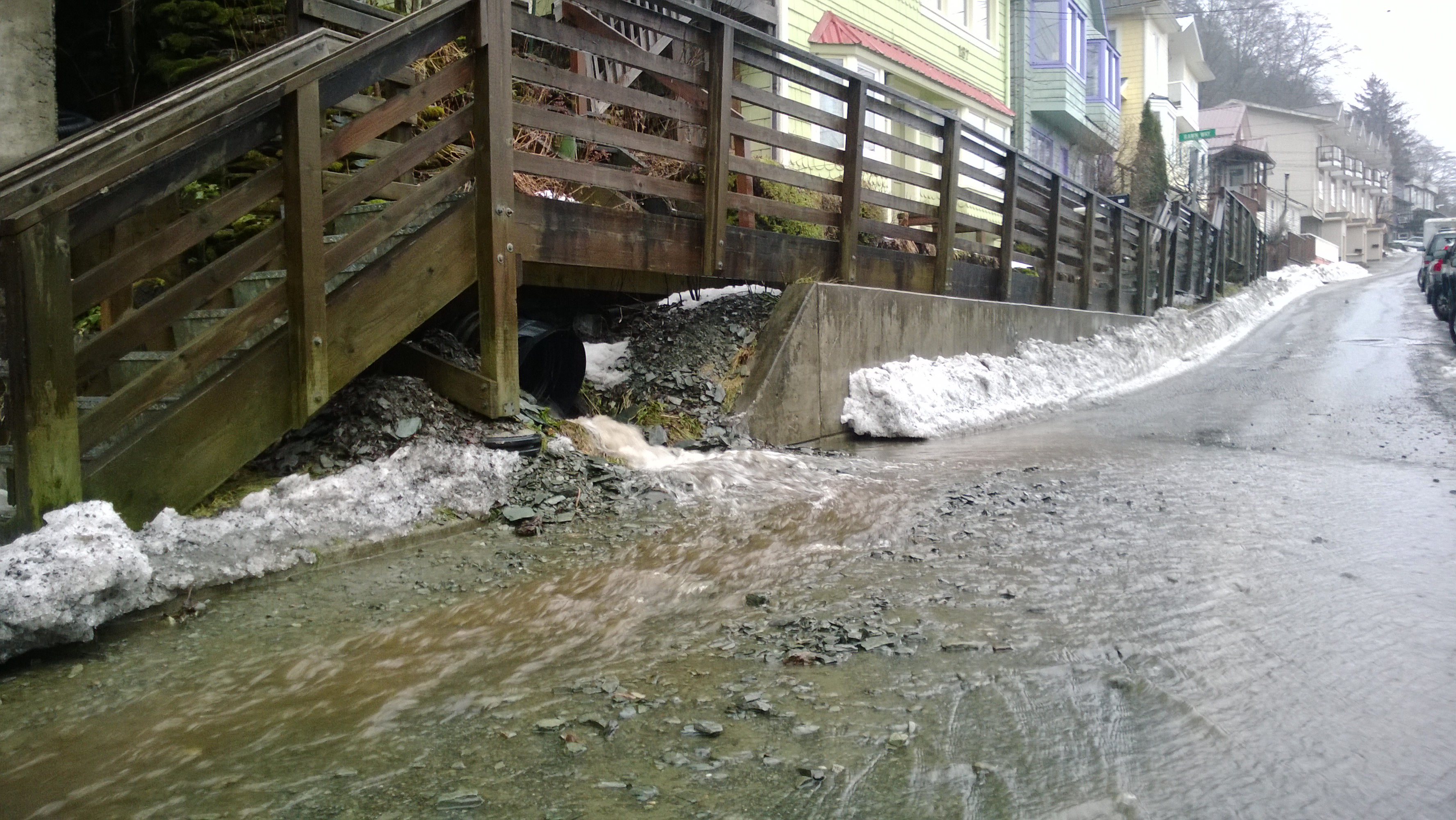 Muddy water and small debris gush from a culvert onto Gastineau Avenue on Tuesday. (Photo by Jeremy Hsieh/KTOO)