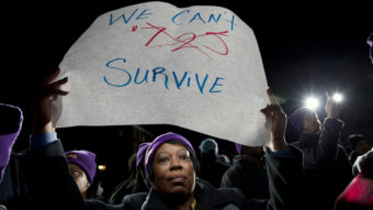 Darlene Handy of Baltimore holds up a banner at a rally supporting a pay measure in Maryland. More than 20 states have raised minimum pay rates above the federal level. Jose Luis Magana/AP