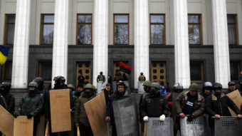 Anti-government protesters stand guard in front of Ukraine's parliament in Kiev on Saturday. (Marko Drobnjakovic/AP)