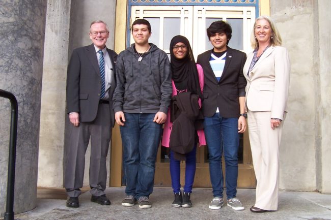 Exchange students from the Middle East Haytham Mohanna, Maha Abdulrazzaq, and Abdulla Husain pose with Sen. Dennis Egan and Rep. Cathy Munoz during a visit to the Capitol in January. (Photo courtesy of Alida Bus)