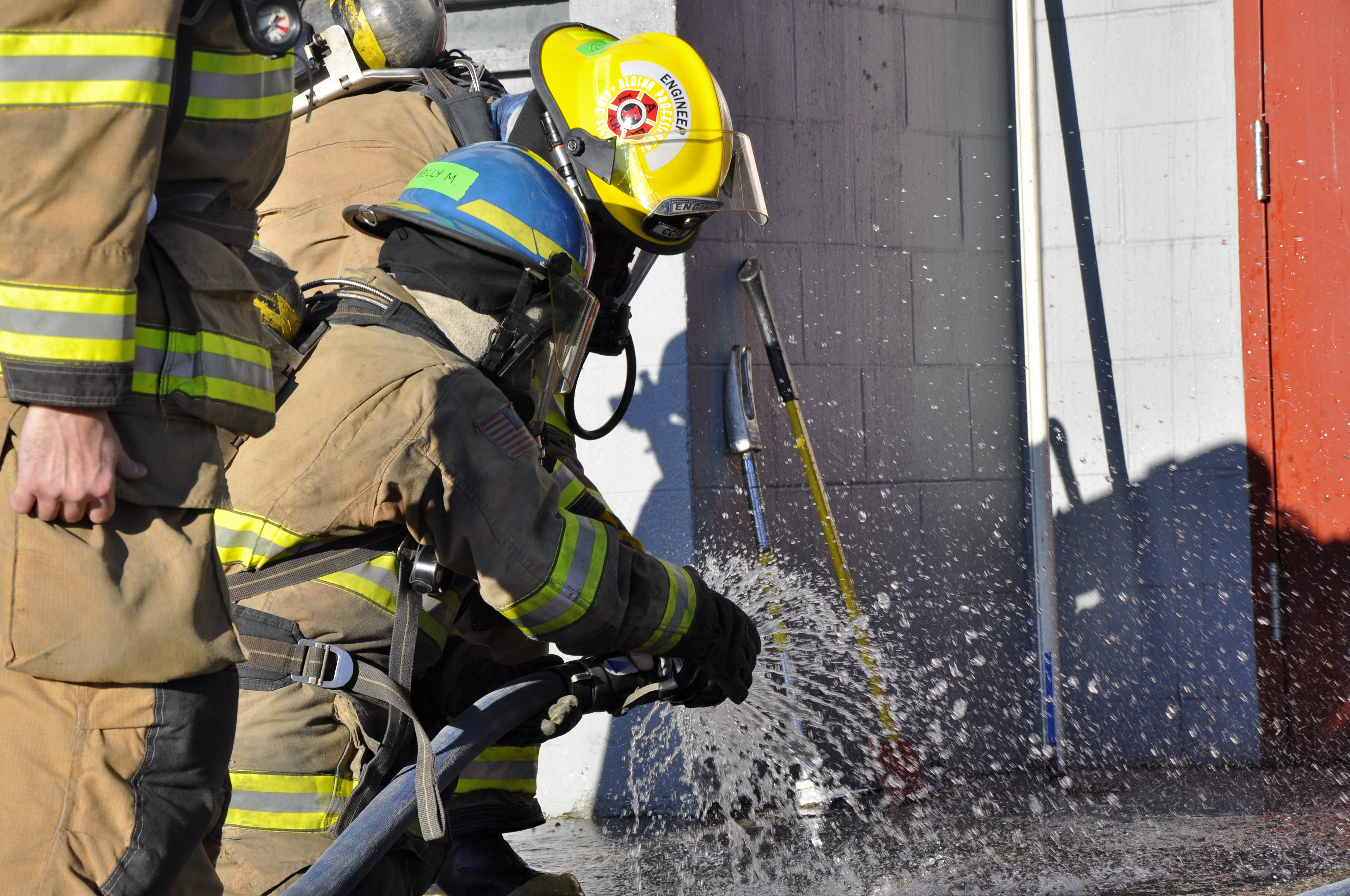 A training participant checks the water flow at Hagevig Fire Training Center before putting out a controlled fire. Photo by Annie Bartholomew/KTOO