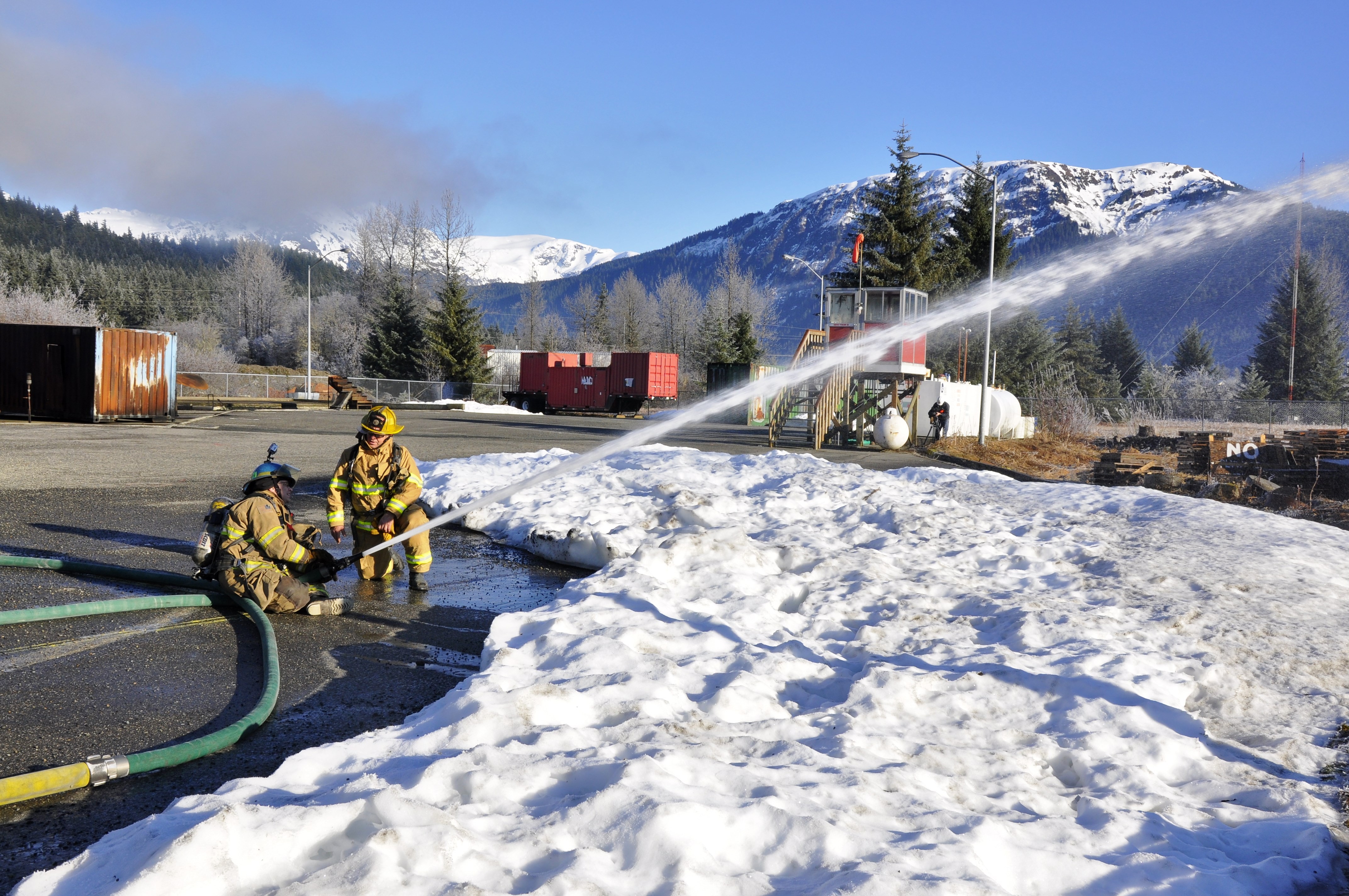 KTOO reporter Matt Miller learns how to operate a fire hose from his "shadow" firefighter Erik Goldsberry at Hagevig Fire Training Center. Photo by Annie Bartholomew/KTOO