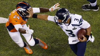 Quarterback Russell Wilson (#3) of the Seattle Seahawks stiff arms cornerback Champ Bailey (#24) of the Denver Broncos during Super Bowl XLVIII at MetLife Stadium on Sunday in East Rutherford, N.J. Jeff Zelevansky/Getty Images