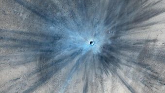 An enhanced image of a newly formed crater on Mars. The feature, including the ejected material, stretches more than 9 miles across. NASA