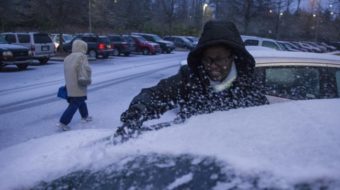 Shmetrice Moore, a nurse at Emory University Hospital, was scraping snow and ice off her windshield early Wednesday in Atlanta. John Amis/AP