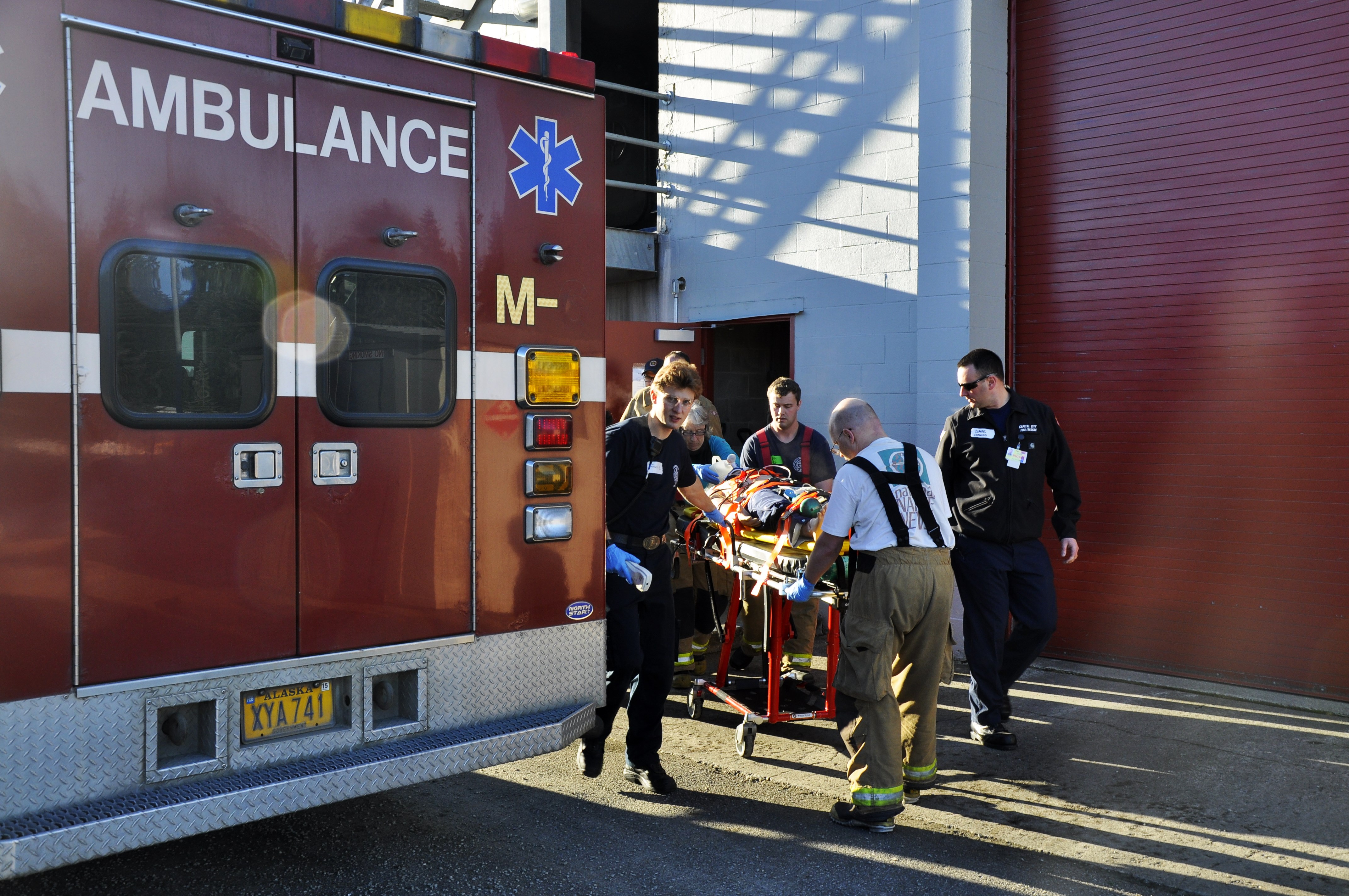 Participants rush the dummy into the ambulance as if it were a real patient at Hagevig Fire Training Center. (Photo by Annie Bartholomew/KTOO)