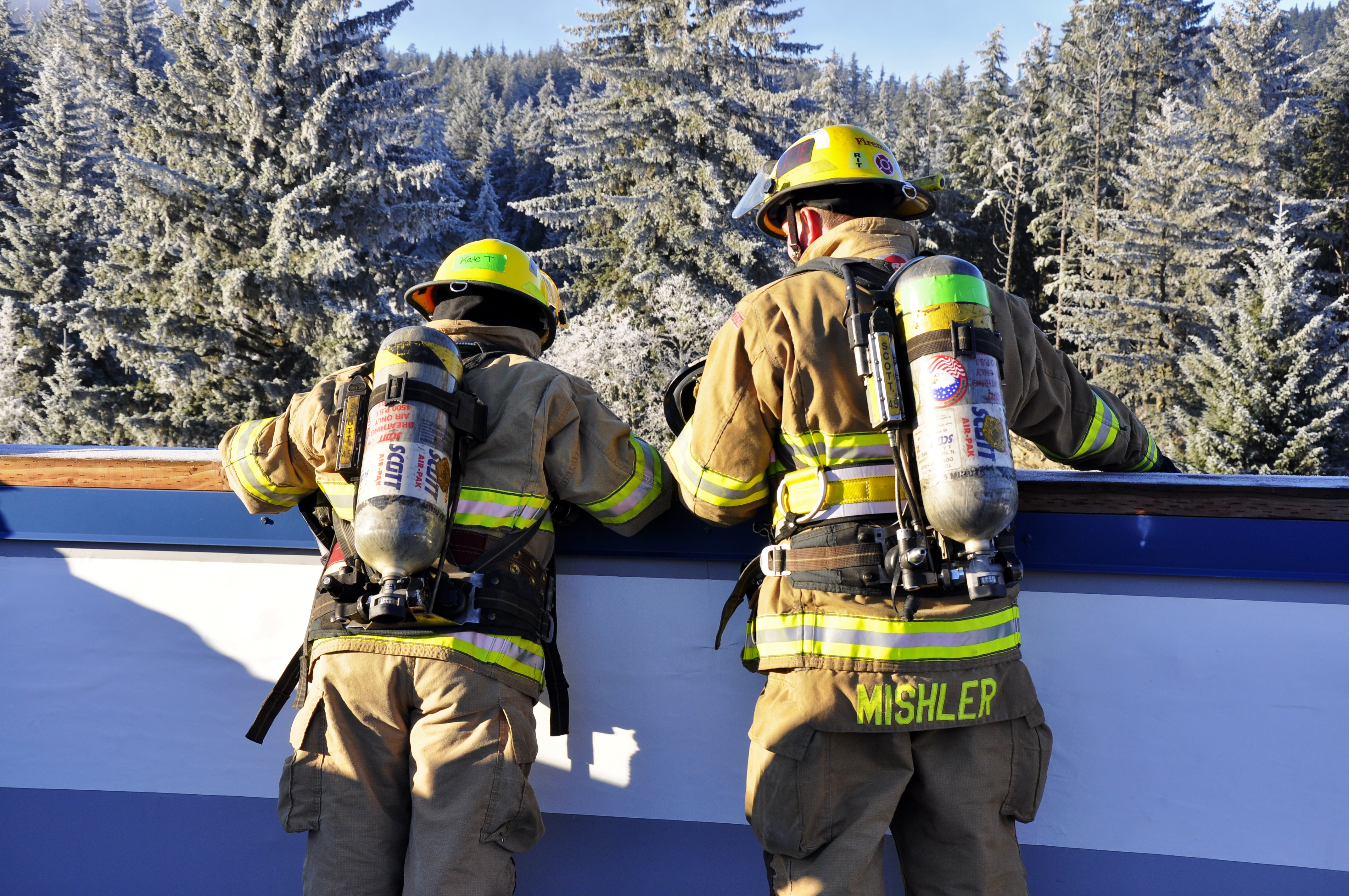 Juneau Assembly member Kate Troll talks to her "shadow" firefighter Joe Mishler after climbing the ladder to the top of the building. Photo by Annie Bartholomew/KTOO