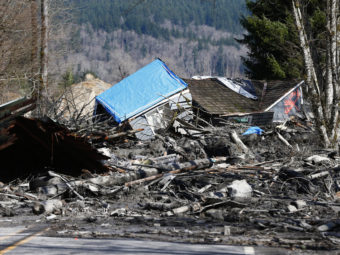 A destroyed house sits in muddy debris near Oso, Wash., on Sunday. A rain-soaked hillside let loose a wall of mud Saturday, inundating neighborhoods along the Stillaguamish River's North Fork. Lindsey Wasson/AP