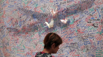 A woman reads messages for passengers aboard a missing Malaysia Airlines plane at a shopping mall in Kuala Lumpur, Malaysia on Saturday. Lai Seng Sin/AP