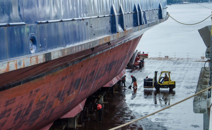 Shipyard workers clean the deck in preparation for lowering the Matanuska back into the water.