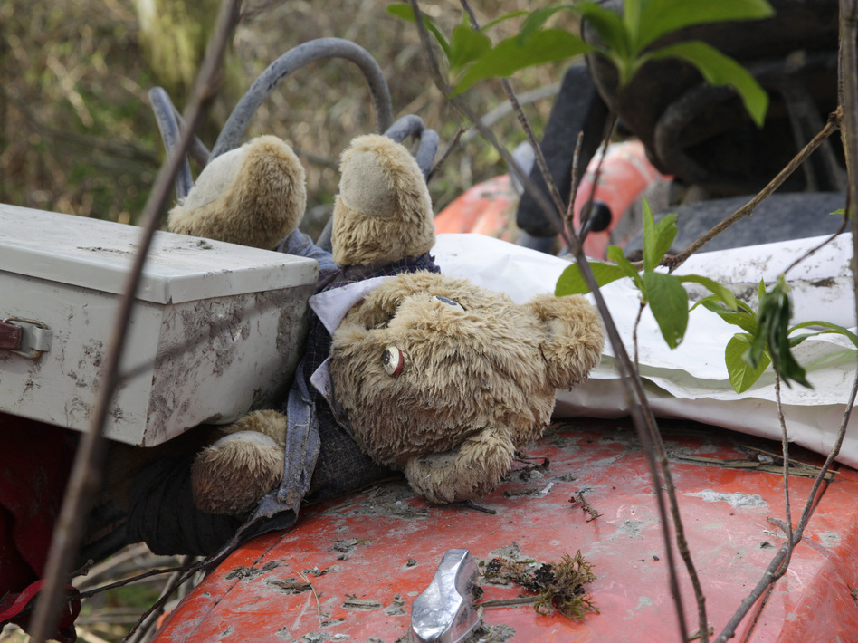 A stuffed bear sits with other items found nearby Wednesday atop a tractor that landed at the edge of the debris field in a deadly mudslide in Oso, Wash. Elaine Thompson/AP