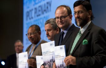 The world must cut its greenhouse gas emissions to meet its goals, climate experts said Sunday. Members of the Intergovernmental Panel on Climate Change (left to right) Youba Sakona, Ramon Pichs Madruga, Ottmar Edenhofer and Rajendra Pachauri hold copies of their new report in Berlin. John MacDougall/AFP/Getty Images