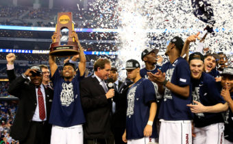 Ryan Boatright of the Connecticut Huskies holds up the NCAA championship trophy after defeating the Kentucky Wildcats 60-54 at AT&T Stadium on Monday, as his teammate Shabazz Napier is interviewed after the game. Jamie Squire/Getty Images
