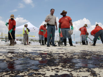 BP Mobile Incident Commander Keith Seilhan talks with oil cleanup workers in Gulf Shores, Ala., in July 2010. Seilhan has settled with SEC regulators who say he avoided $100,000 in stock and options losses by trading on inside information related to the spill. Dave Martin/AP