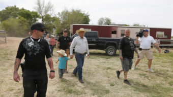 Rancher Cliven Bundy (center) walks with his grandson Braxton Louge along with armed security guards near his ranch house Friday. Bundy's ranch, west of Mesquite, Nev., has become a rallying point for protesters who back his fight against the Bureau of Land Management over grazing fees. George Frey/Getty Images