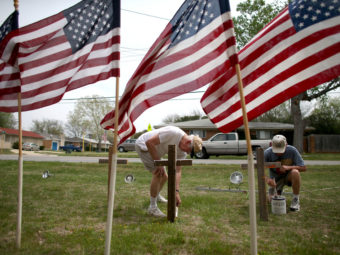 Bob Butler (left) and Bob Gordon paint crosses they placed in front of American flags at Central Christian Disciples of Christ church in the city of Killeen, Texas, which is home to Fort Hood. Joe Raedle/Getty Images