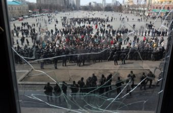 A photo taken through a shattered window shows pro-Russian protesters in front of Ukrainian police guarding the Kharkiv regional state administration building Tuesday. AFP/Getty Image