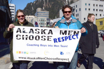 Supporters of the Coaching Boys into Men project carry a sign down Main Street in Juneau during rally on March 27, 2014. The campaign aims to reduce domestic violence in Alaska. The state leads the nation in domestic violence rates. (Photo by Skip Gray/Gavel Alaska)