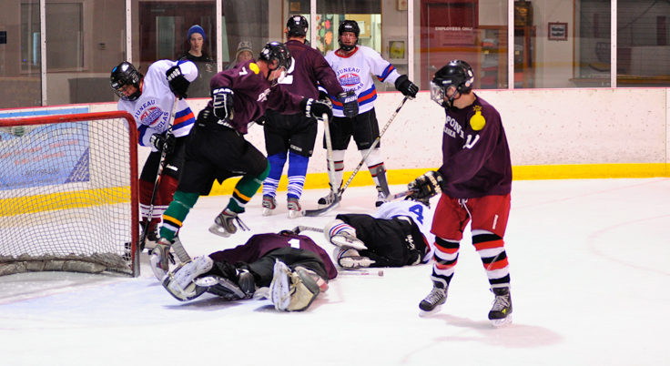 Bodies often fly when things get crowded in front of a net as this scrum illustrates.