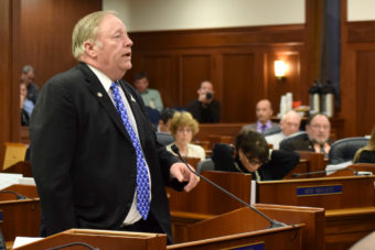 House Speaker Mike Chenault stepped down from the dais Sunday, April 13, 2014, to speak out against minimum wage ballot organizer Ed Flanagan's holding of a dollar symbol sign in committee, and the perception of corruption it could have implied. (Photo by Skip Gray/Gavel Alaska)