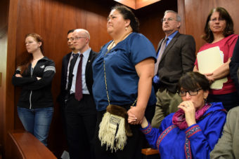 In the Senate gallery, an emotional Rep. Charisse Millett holds hands with Liz Medicine Crow while Senators debate the fate of the bill. The legislation, which passed moments later, makes 20 Alaska Native languages official state languages alongside English. (Photo by Skip Gray/Gavel Alaska)