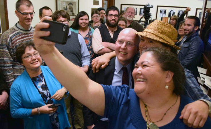 Rep. Jonathan Kreiss-Tompins (center) celebrates by posing for a “selfie” with supporters of House Bill 216, his legislation making 20 Alaska Native languages official state languages alongside English. The bill had passed the Senate only moments earlier at 3 a.m., April 21, 2014. (Photo by Skip Gray/Gavel Alaska)