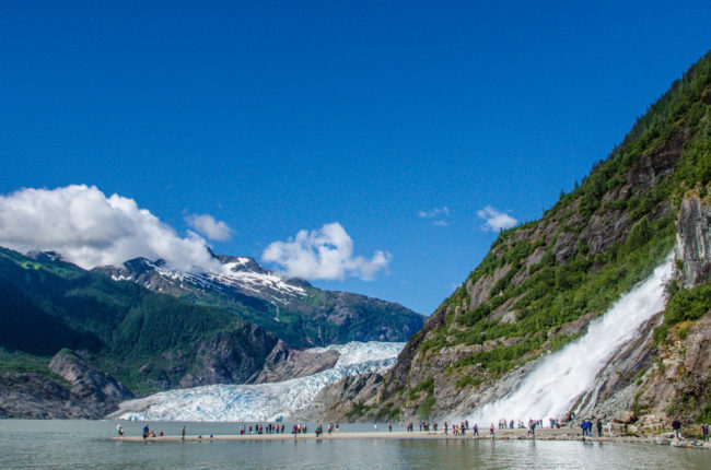 Summer tourists surround Nugget Falls during a visit to Mendenhall Glacier. (Photo by Heather Bryant/KTOO)