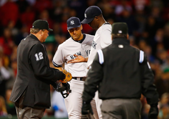 Home plate umpire Gerry Davis checks out the hand of Michael Pineda of the New York Yankees in front of teammate Derek Jeter before throwing him out of the game in the second inning against the Boston Red Sox. (Jared Wickerham/Getty Images)